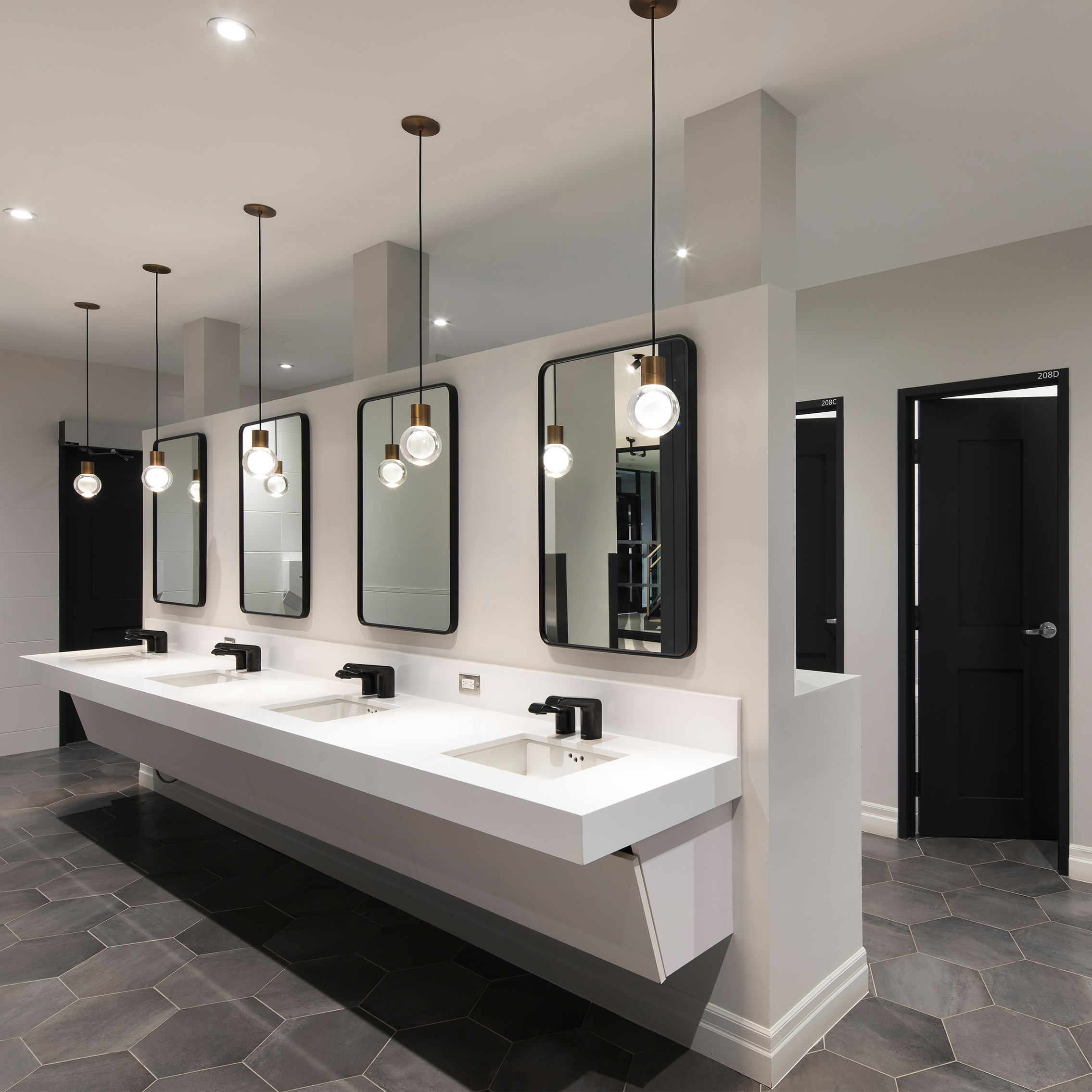 A black and white bathroom with decorative light fixtures.