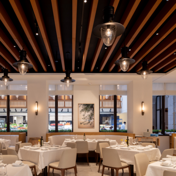 Photo of a bright dining room with wood ceiling and eye-catching light fixtures. 