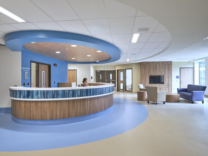 Image of a blue and wood rounded reception desk in the hospital.